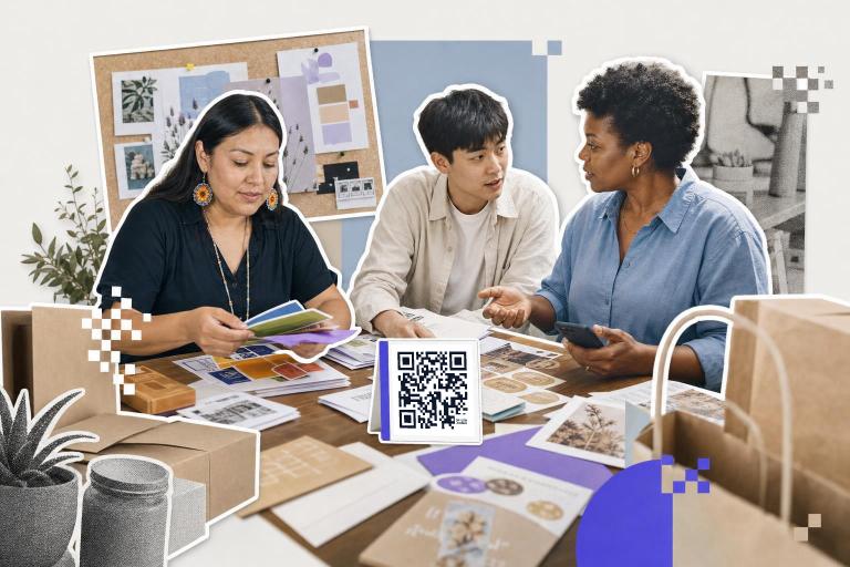 Three people discussing design materials at a table with a qr code card in the center.