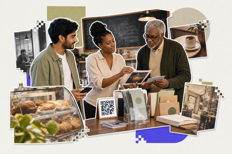 Three people in a cafe discussing a photo with a custom QR code generator card on the table.