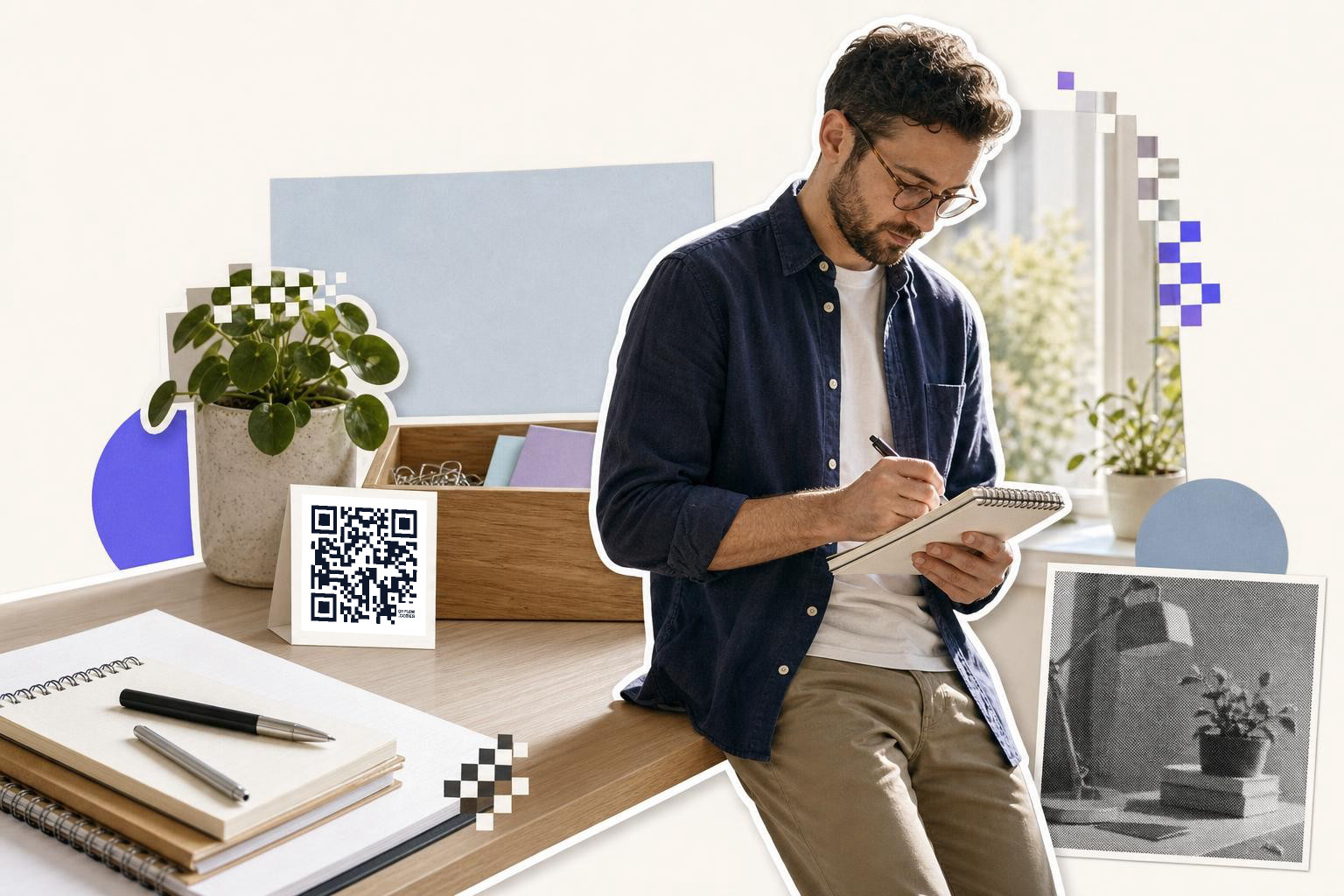 A man with glasses sits on a desk, writing in a notebook, with a printed card featuring a QR code nearby, in a bright setting.