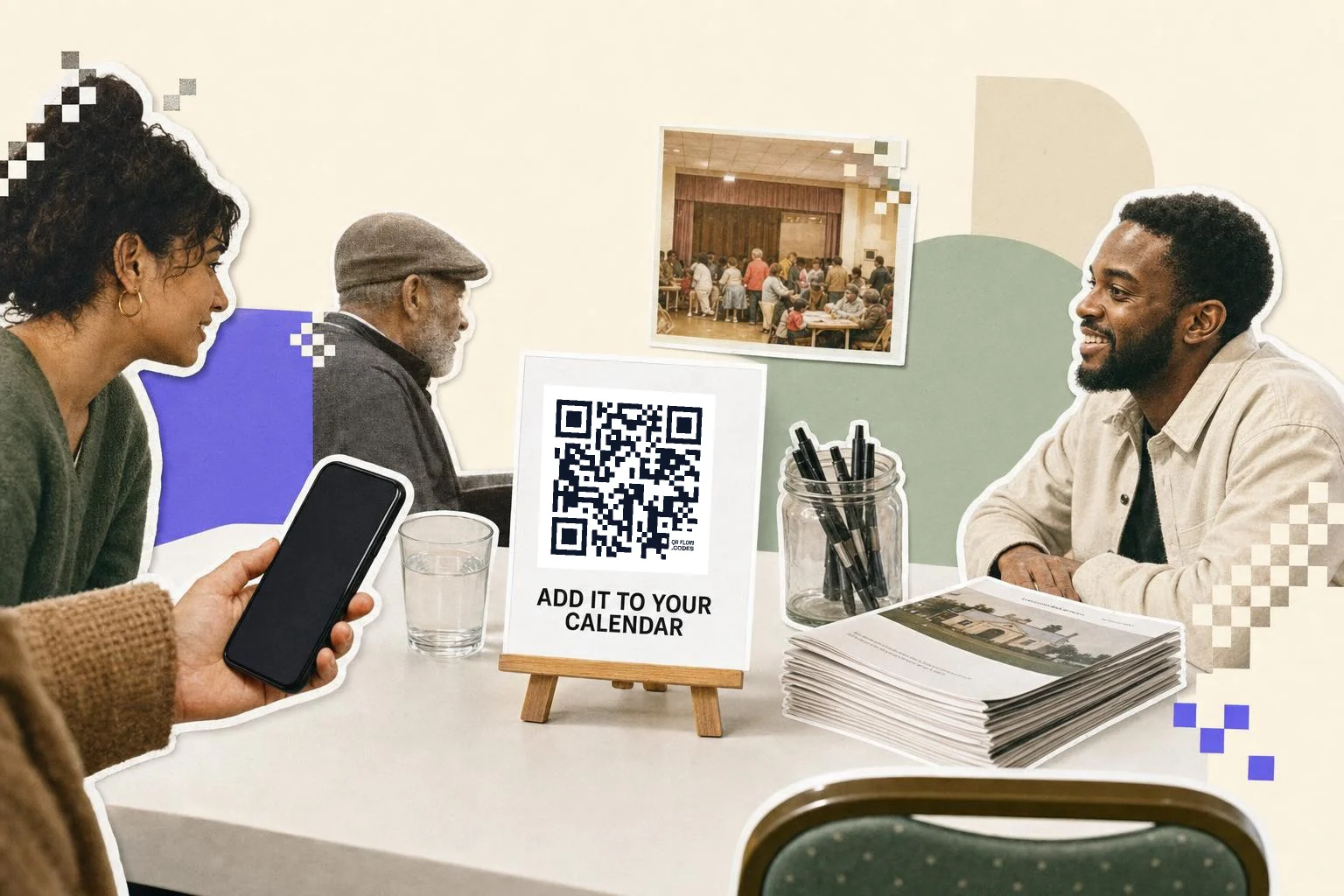 A community hall table: a white card on a small wooden easel carrying a QR code and the words Add it to your calendar, a jar of pens, a stack of printed programmes and a glass of water, three people talking around the table, a hand holding a phone toward the card