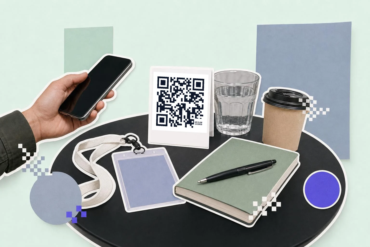 A conference side table: a white card in a stand carrying a QR code, a blank lanyard badge, a green notebook and pen, a glass of water and a takeaway coffee cup, a hand holding a phone toward the card